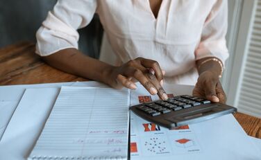 Person rechnet mit einem Taschenrechner.