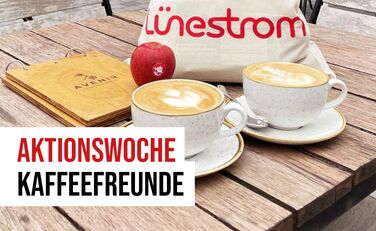 Zwei Cappucchino-Tassen, Lünestrom-Beutel, Apfel und Avenir-Speisenkarten, davor Schriftzug "Aktionswoche Kaffeefreunde"