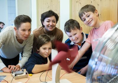 Zwei Lünestrom-Mitarbeiterinnen und drei Schüler an der Windenergie-Station des mobilen Energielabors vom SCHUBZ in Kooperation mit Lünestrom.